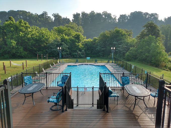 a pool with chairs and tables on a deck